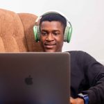 NiYA Sock Image_A youth sitting on a couch, smiling at his phone (2)